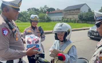 Polres Subang Gelar Operasi Keselamatan Lodaya 2025 dengan Pendekatan Berbeda Polisi memberhentikan pemotor tertib untuk diberi hadiah (Foto: Istimewa)